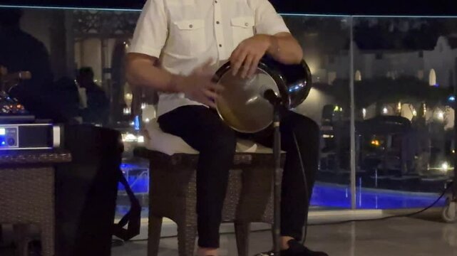 Sharm El Sheikh Egypt June 07.2025 Arab man play oud, lute or mandola isolated traditional music instrument Asia. Islamic culture musician boy middle east street performer tourist attraction. 
