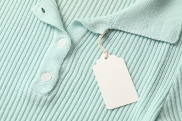 Cardboard tag on turquoise garment, above view