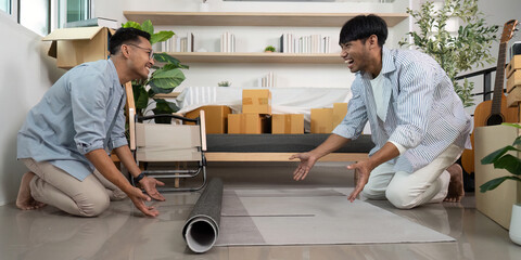 Happy gay couple laying down a rug in their new living room