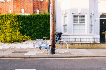 Light blue bicycle parked on a london street in a residential neighborhood
