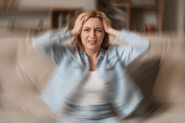 Mature woman suffering from headache at home