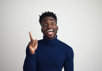 Excited Man in Blue Turtleneck Pointing Up – Portrait with Happy Expression, White Background, Ample Space for Text, High-Resolution Studio Photography for Advertising & Social Media Concepts