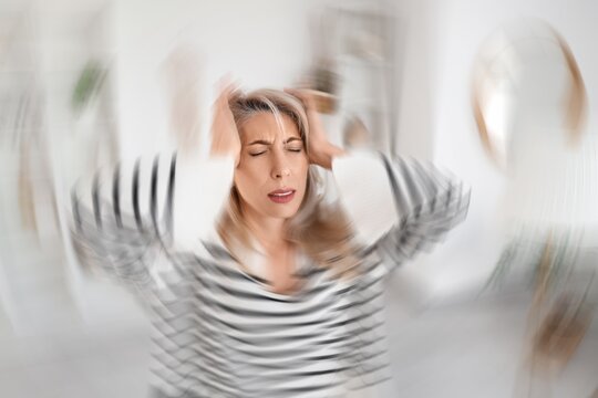 Mature woman with migraine at home