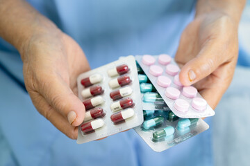Asian elderly woman patient holding drug in her hand, healthy strong medical concept.
