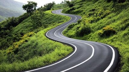 A winding asphalt road curves through lush green hills under a cloudy sky, surrounded by dense vegetation and trees.