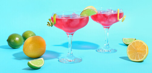 Glasses of tasty cosmopolitan cocktail on color background