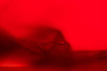 Extreme close up of red empty plastic bag background. The plastic surface is wrinkly and tattered...