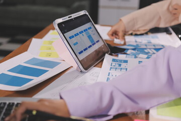 Close up ux developer and ui designer brainstorming about mobile app interface wireframe design on...