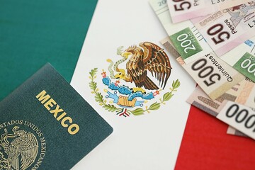 Mexican pesos money bills in big amount and passport lies on Mexico flag close up