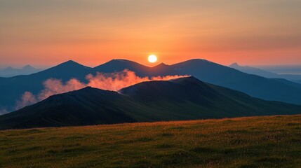 Obraz premium Majestic sunrise paints the mountain peaks with warm hues, mist clinging to the valleys below