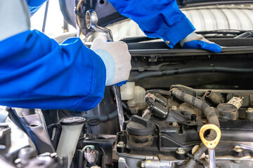 Close up auto mechanic hands holding tool fixing car in repair shop
