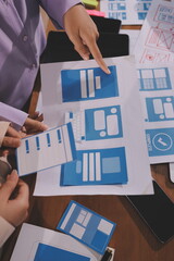 Close up ux developer and ui designer brainstorming about mobile app interface wireframe design on...