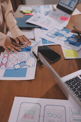 Close up ux developer and ui designer brainstorming about mobile app interface wireframe design on...