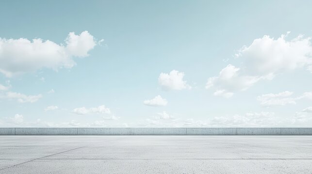 A vast, empty concrete surface under a bright blue sky filled with scattered white clouds.