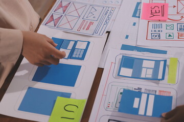 Close up ux developer and ui designer brainstorming about mobile app interface wireframe design on...