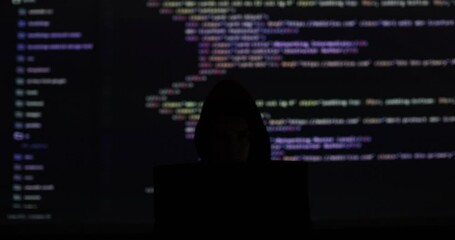 No face hacker with laptop with abstract programming code in the background. Man hacker working on laptop at night. Digital system security. - Powered by Adobe