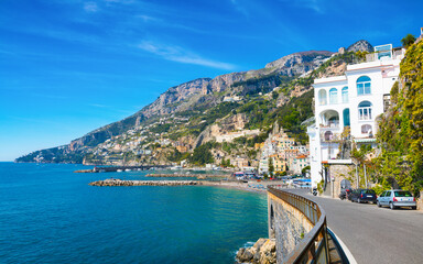 Coastal town Amalfi, Italy, nestled among steep cliffs and overlooking Mediterranean Sea. Colorful buildings line hillside and road winds along coastline. Amalfi offers iconic coastal charm