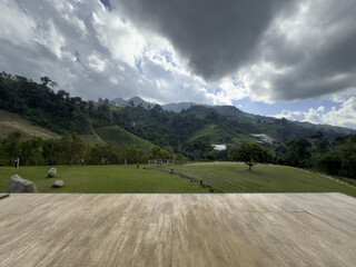 Wooden Deck with Scenic Mountain View Under Cloudy Sky
