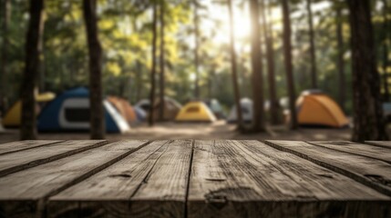 Wooden table surface with blurred forest background featuring tents and sunlight filtering through the trees during daytime.