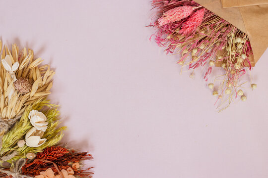 Delicate dried flower frame on pink background, ideal for floral shop branding, greeting cards, invitations, social media, wedding decor, seasonal promotions, and elegant advertising campaigns. - Powered by Adobe