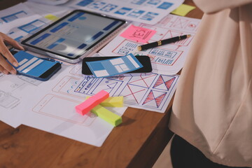 Close up ux developer and ui designer brainstorming about mobile app interface wireframe design on...