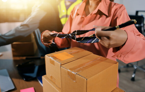 Startup SME small business entrepreneur of freelance Asian woman wearing apron using laptop and box to receive and review orders online to prepare to pack sell to customers, online sme business ideas.
