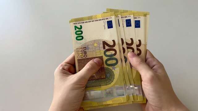 Counting euro banknotes. Female hands count 200 euros cash. Investments, family budget and savings concept