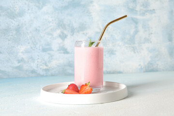 Glass of tasty strawberry smoothie on table