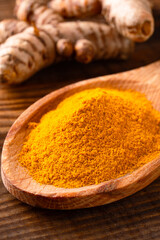 Turmeric with its magnificent orange color on a vintage wooden background