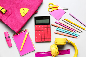 Backpack with calculator, stationery and headphones on white background