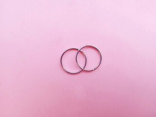 a pair of silver rings isolated on a pink background. silver fashion jewelry