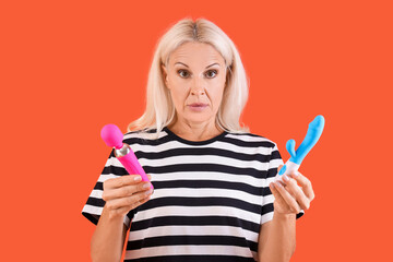 Shocked mature woman with vibrators on red background