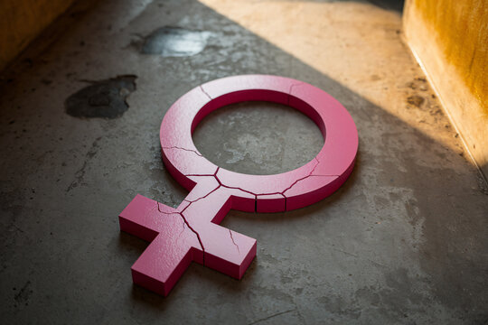 Cracked pink female gender symbol on concrete floor representing femicide