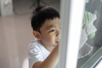 Cleaning and Focus. Young boy cleaning window with determination.