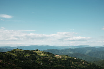 Scenic spring landscape of rolling hills and distant mountains under a blue sky in Serbia. Rural...