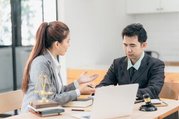 Professional business people working and discussing in law office. Judge's gavel with scales of justice. Consultation and discussion meeting in law office.