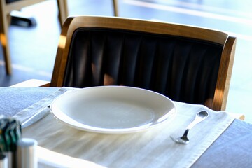 Dinner preparations in luxury restaurant. Forks and knives, serving plates. Waiters preparing tables for customers. Dining table and chair, Bosphorus view. White tablecloths. Service industry.