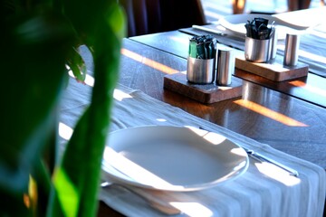 Dinner preparations in luxury restaurant. Forks and knives, serving plates. Waiters preparing tables for customers. Dining table and chair, Bosphorus view. White tablecloths. Service industry.