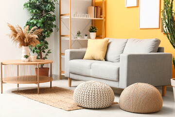 Interior of modern living room with coffee table, sofa and poufs