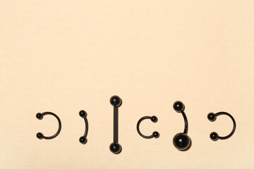 Set of black jewelry for piercing on color background