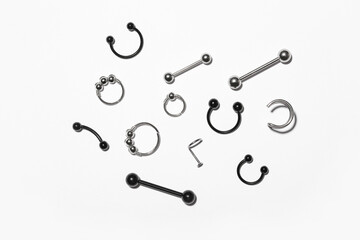 Composition with stylish jewelry for piercing on light background