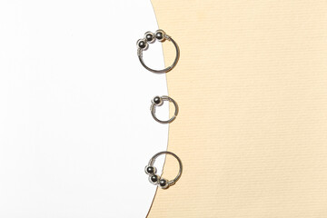 Set of stylish rings for piercing on color background