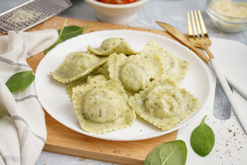 Plate of tasty ravioli on white background