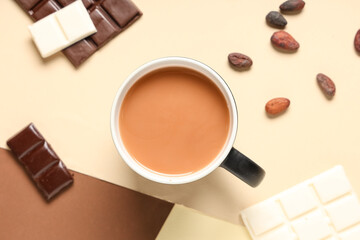Cup of tasty hot chocolate with cocoa beans on color background