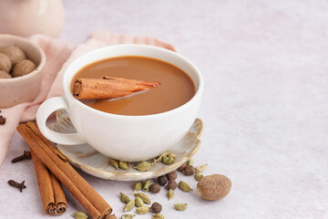 Cup of tasty masala tea with different spices on light background, closeup