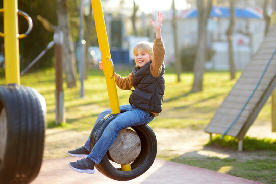 Cute preteen boy having fun on outdoor playground. Spring summer autumn active sport leisure for child. Activity for family with children. Equipment of entertainment park for kids.