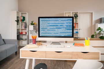 Computer monitor with code and stationery on programmer's desk in office