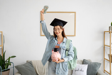 Female student in graduation hat with piggy bank and money at home. Education savings concept