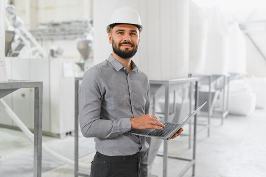 Engineer using laptop and inspecting production in food processing plant