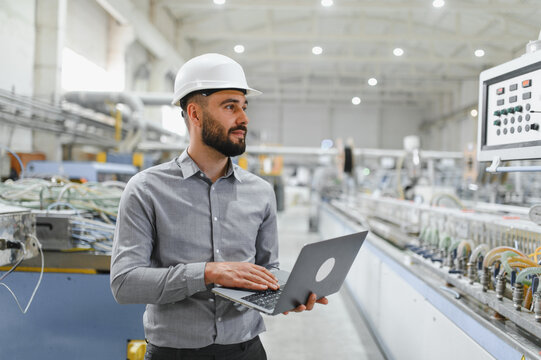 Industrial engineer working on laptop in modern factory